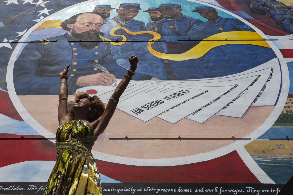 Dancer Prescylia Mae, of Houston, performs during a dedication ceremony for the massive mural "Absolute Equality" in downtown Galveston, Texas, Saturday, June 19, 2021. The dedication of the mural, which chronicles the history and legacy of Black people in the United States, was one of several Juneteenth celebrations across the city.  (Stuart Villanueva)
