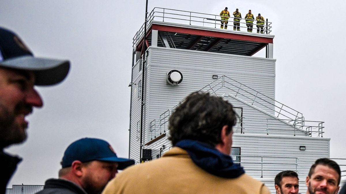 Spokane Valley Fire Department firefighters watch the ribbon cutting for the new training facility on Thursday from the top of the burn tower.  (Kathy Plonka/The Spokesman-Review)