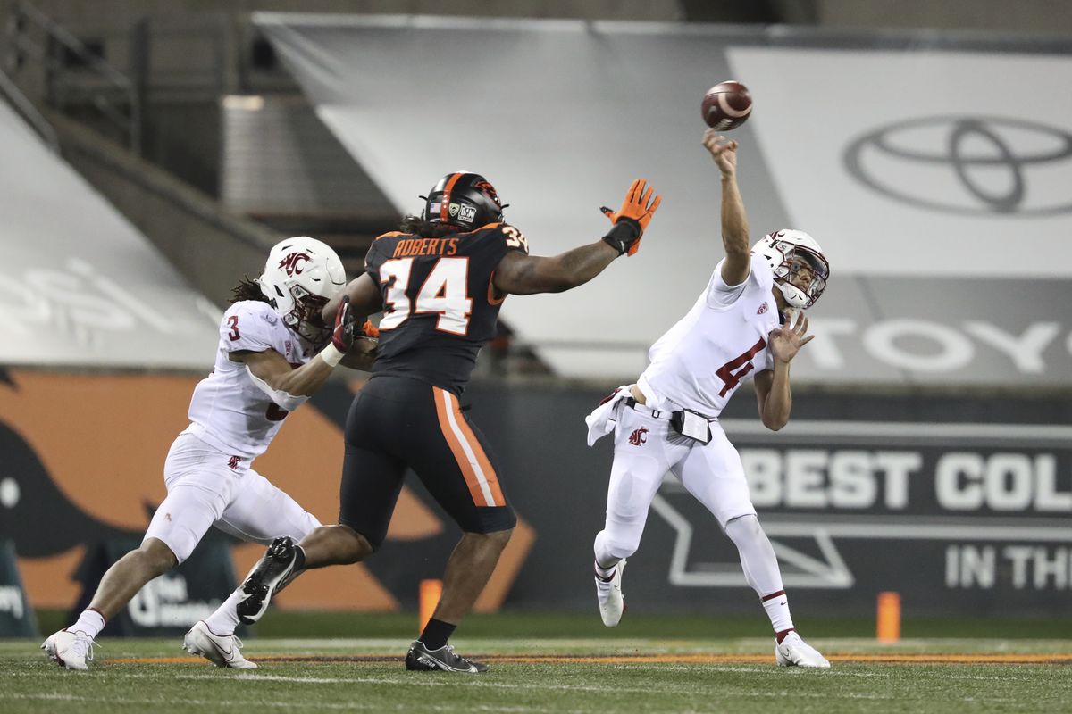 Washington State quarterback Jayden de Laura throws past Oregon State inside linebacker Avery Roberts while WSU running back Deon McIntosh blocks during Saturday’s season-opening game in Corvallis, Ore.  (Associated Press)