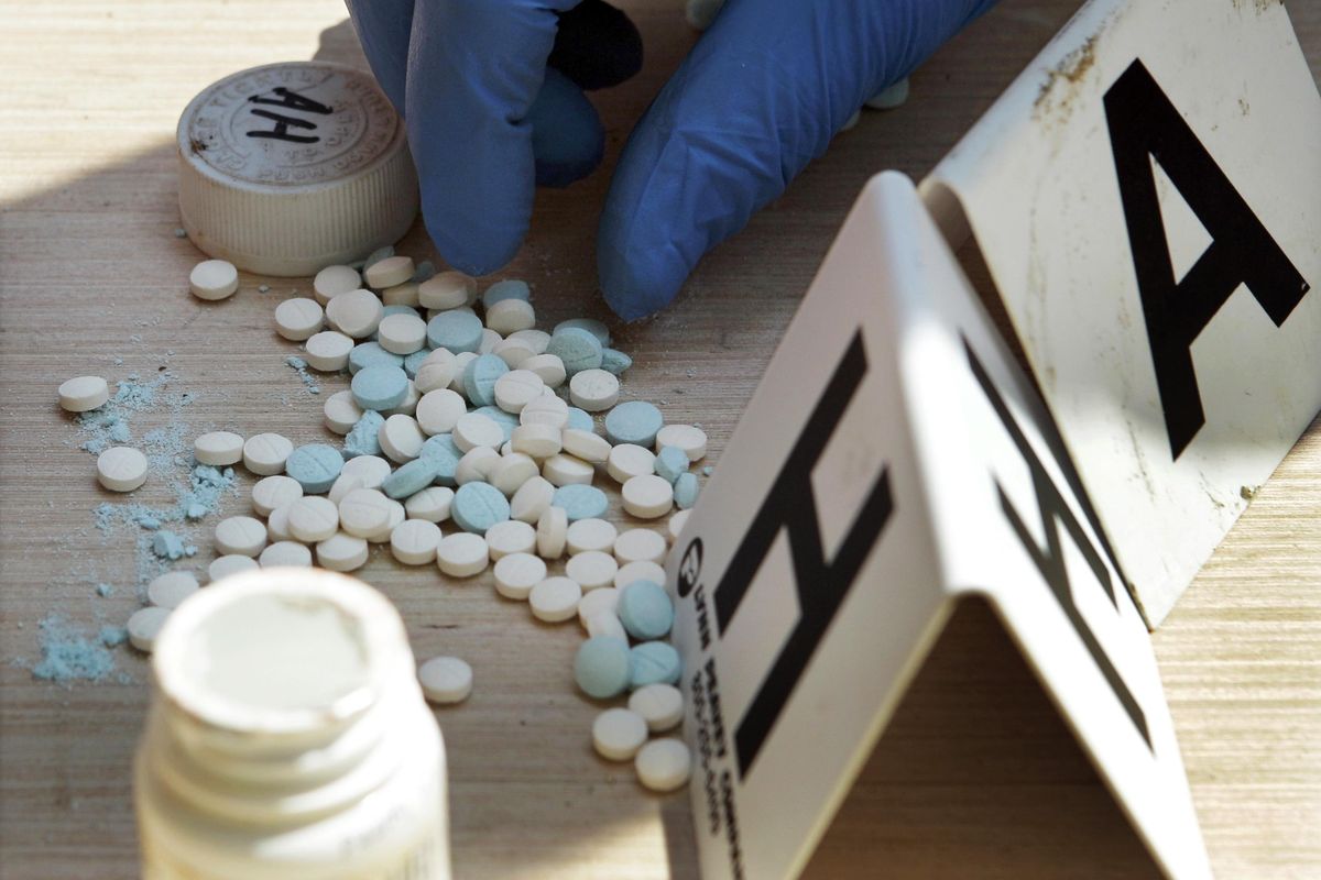 In this Sept. 2, 2010, photo a police officer in Franklin County, Montana, counts pills containing pseudoephedrine during a raid of a suspected meth house in Gerald, Mo. Methamphetamines continue to make an alarming surge across the country and in Spokane. (Jeff Roberson / AP)
