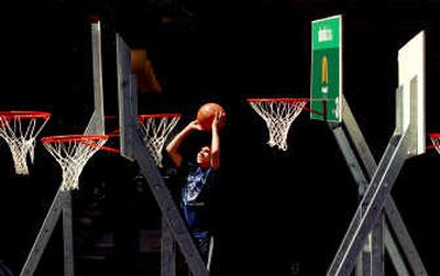 
Michael Carlson, of Bellevue, Wash., does an improvised dunk Friday along Howard Street. Carlson will play with his team, the Superstars, when Hoopfest begins today.
 (Brian Plonka / The Spokesman-Review)