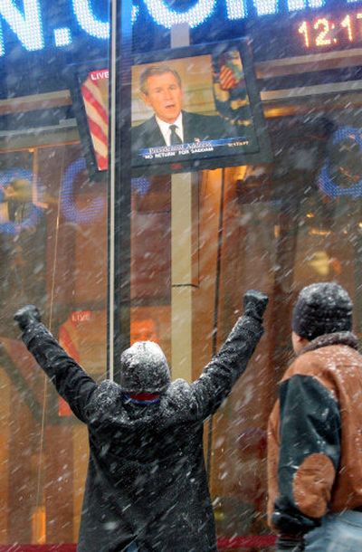 
Pedestrians in New York celebrate as President Bush addresses the nation after the capture of Saddam Hussein on Dec. 14, 2003. 
 (Associated Press / The Spokesman-Review)