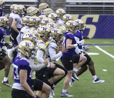 University of Washington players warm up before performing drills in Husky stadium in Seattle during NCAA football practice, Wednesday, March 30, 2022.  (Steve Ringman/Seattle Times)