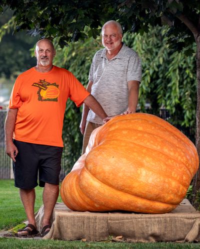 Gerry Klumb, left, grew the biggest pumpkin (over 800 pounds) entered into this year’s Spokane County Interstate Fair, while his neighbor, Greg Johnson, also grew a large pumpkin fair entry.  (Colin Mulvany/THE SPOKESMAN-REVIEW)