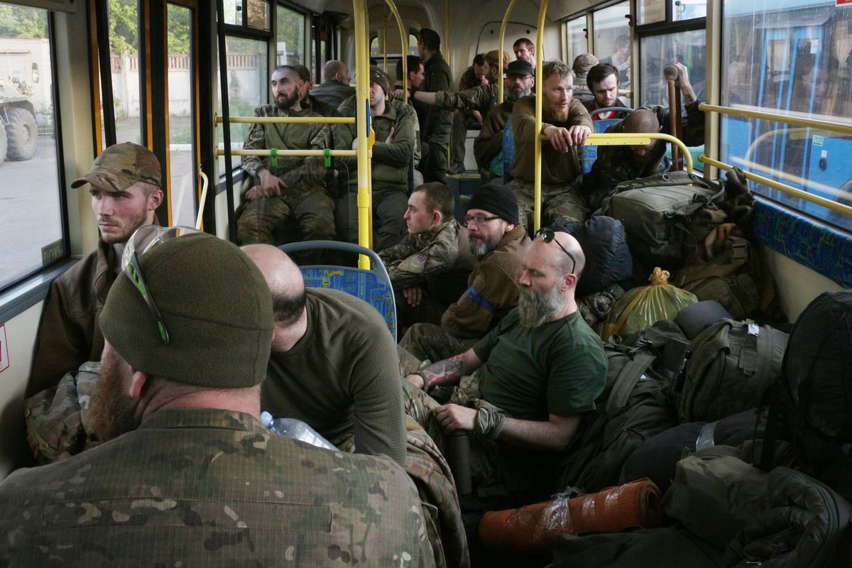Ukrainian servicemen sit in a bus after they were evacuated from the besieged Mariupol
