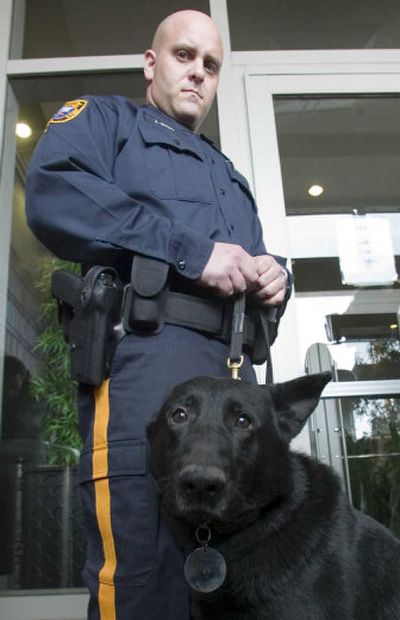 
One of the arresting officers, Officer Joseph Buda, and police dog Britt, attend Friday's news conference.
 (Associated Press / The Spokesman-Review)