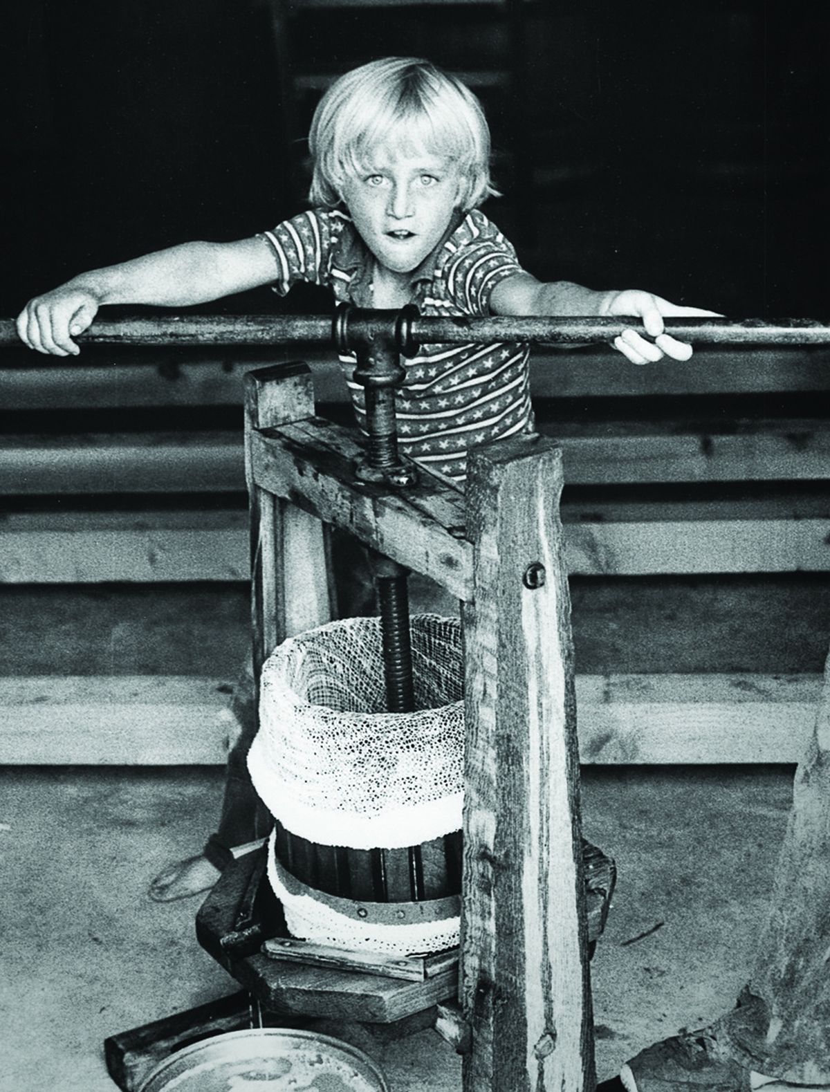 Adam Campbell crushes grapes by hand as a boy in 1978. Today, Campbell runs Elk Cove Vineyards, which his parents started in 1974.