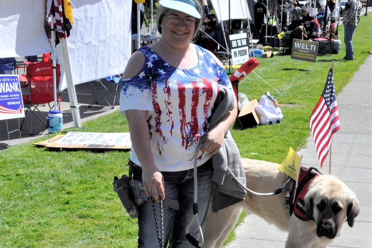 OLYMPIA – Shaila Martin, of Nine Mile Falls, came to the March for Our Rights rally with Sansa, an Anatolian Shepherd and Great Pyrennees mix, and Karma, a shepherd puppy. She said she’s part of the the Three Percent movement and “not real happy about what they’re trying to do to take away our rights.” (Jim Camden / The Spokesman-Review)