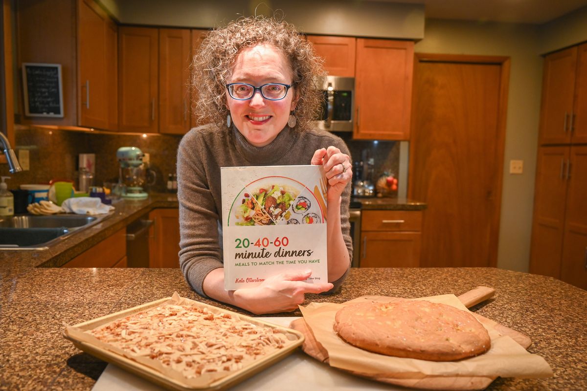 Food blogger Kate Otterstrom has recently produced a new book: “20-40-60 Minute Dinners: Meals to Match the Time You Have.” Otterstrom rewrote the book she wrote several years ago, adding gluten-free recipes after she was diagnosed with celiac disease. She is shown at her Spokane home Tuesday, Jan. 23, 2024, with her gluten-free almond Texas sheet cake and a focaccia bread made from a dough recipe in the book.  (Jesse Tinsley/The Spokesman-Review)