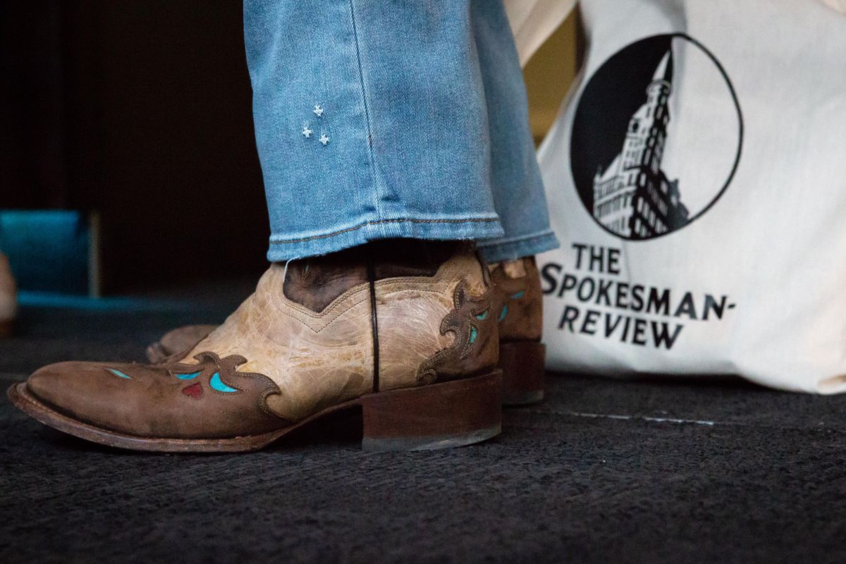 Author Pam Houston wears cowboy boots next to her Spokesman-Review tote bag at a Northwest Passages VIP event on Tuesday, March 26, 2019 at Ovations Bar in the Bing Crosby Theater. Houston