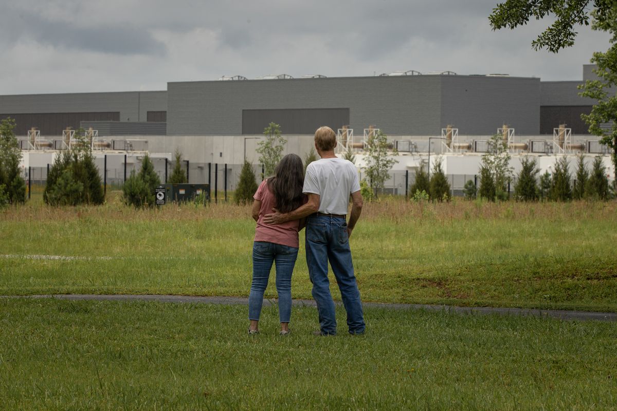 Jeff and Beverly Morris look at Meta’s data center from their front yard in May in Newton County, Ga.  (DUSTIN CHAMBERS)