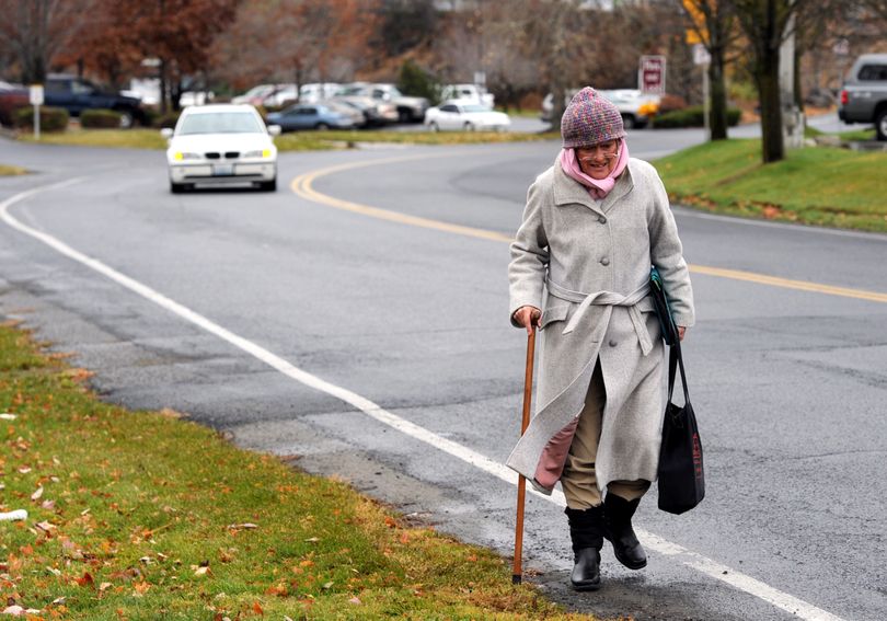 Lois King walks along North River Drive on Friday, a route she uses for doctor visits. King is concerned about the condition of sidewalks, or lack of them, (Jesse Tinsley)