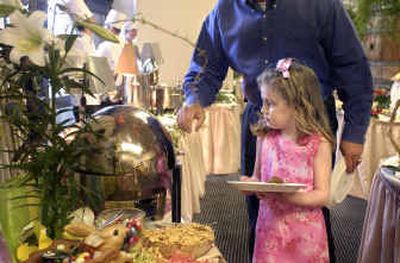 
Six-year-old Olivia Johnston looks over the brunch buffet with help from her dad, Brent, during Beverly's Easter brunch at the Coeur d'Alene Resort on Sunday. 
 (Tom Davenport/ / The Spokesman-Review)