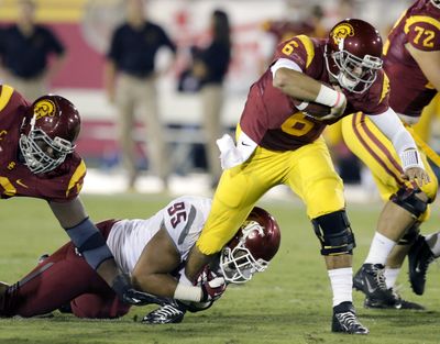 WSU nose tackle Ioane Gauta grabs the leg of USC quarterback Cody Kessler during first-half action in Los Angeles. (Associated Press)