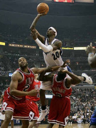 
Wizards guard Larry Hughes, top, drives to the basket against Bulls guard Ben Gordon, right, and center Othella Harrington. 
 (Associated Press / The Spokesman-Review)