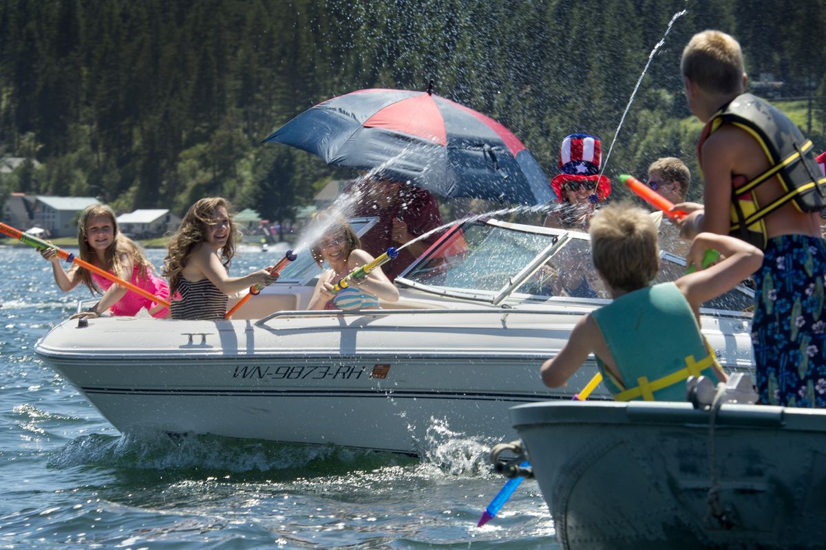 Boaters engage in a water fight with cannons and balloons before the start of the Loon Lake Fourth of July Boat Parade. (PHOTOS BY DAN PELLE)