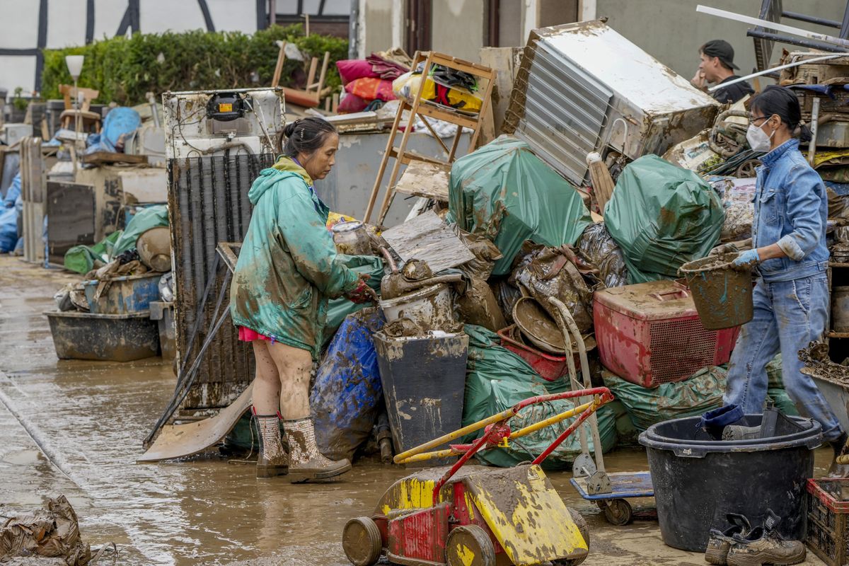 People clean their homes from mud and debris in Bad Neuenahr-Ahrweiler, Germany, Saturday, July 17, 2021. Due to strong rainfall, the Ahr river went over its banks and flooded big parts of the town.  (Michael Probst)