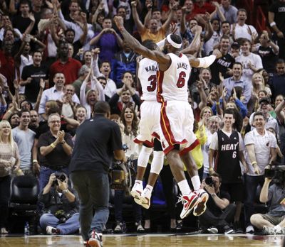 Miami Heat’s Dwyane Wade and LeBron James celebrate after Wade hit the winning shot against Indiana in overtime. (Associated Press)