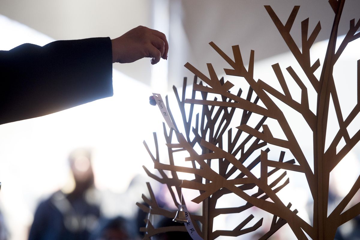 Ornaments with names of Spokane homeless people who passed away while living on the streets are placed on trees during a CHAS memorial event on Wednesday, Dec. 21, 2016, in Spokane. (Tyler Tjomsland / The Spokesman-Review)