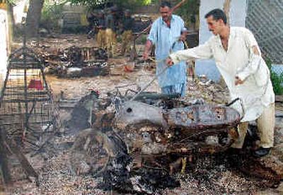 
Plainclothes police officers stand beside a burned motorcycle that was set on fire by angry supporters of a slain Sunni Muslim cleric. Plainclothes police officers stand beside a burned motorcycle that was set on fire by angry supporters of a slain Sunni Muslim cleric. 
 (Associated PressAssociated Press / The Spokesman-Review)