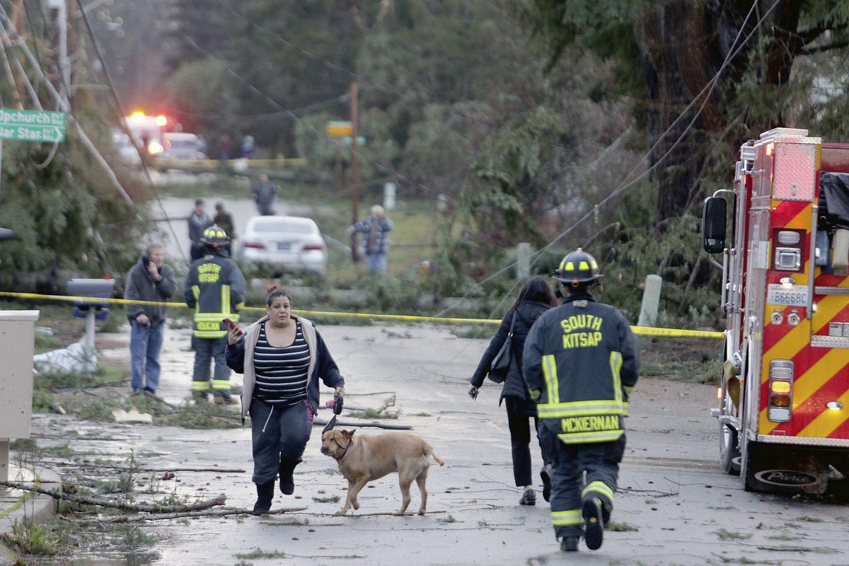 Residents and emergency personnel on Harris Road in Port Orchard, Wash., on Tuesday, Dec. 18, 2018, after a tornado touched down. A rare tornado touched down in a Seattle suburb on Tuesday, damaging several homes and toppling trees, authorities said. (Larry Steagall / Kitsap Sun)