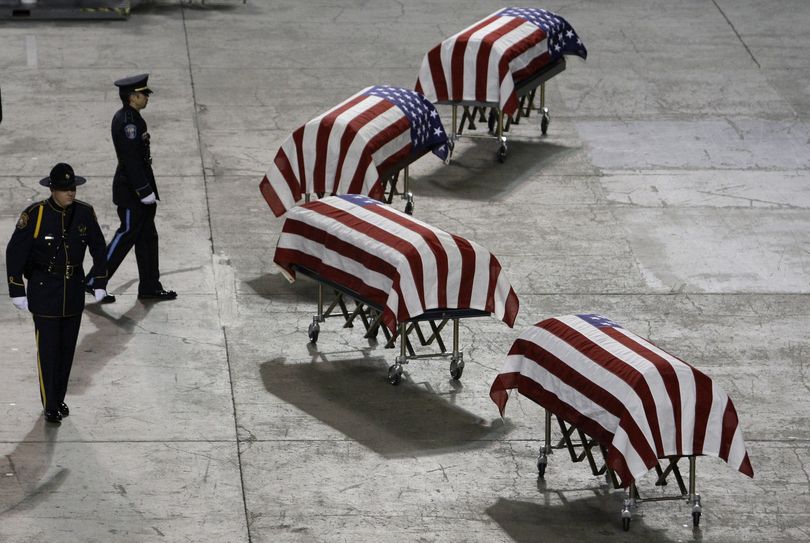 Officers move into position to stand watch at the caskets of four slain Lakewood police officers before a memorial service Tuesday, Dec. 8, 2009, at the Tacoma Dome. (Elaine Thompson / Associated Press)