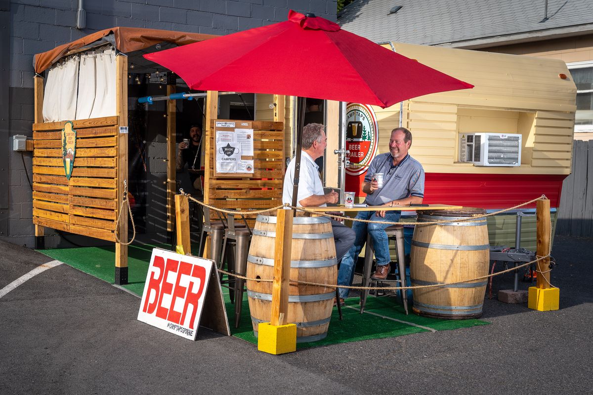 Brothers Mark and Dan Houk enjoy a microbrew after work at Camp Taps Beer Trailer on Aug. 25. Camp Taps has opened in the parking lot of 1889 Salvage Co. at 2824 N. Monroe St. in Spokane.  (Colin Mulvany/The Spokesman-Review)