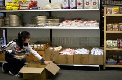 
Brittany Nong prices and unpacks spring roll skins at Lieng and Phane Oriental Market on Sprague Avenue.
 (Liz Kishimoto / The Spokesman-Review)