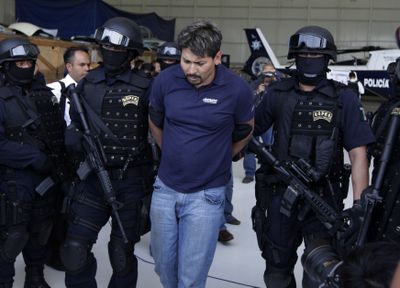 Police escort Arnold Rueda Medina, an alleged coordinator for the Mexican drug cartel known as La Familia,  in Mexico City on Saturday.  (Associated Press / The Spokesman-Review)