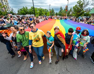 A large rainbow-striped Pride flag is carried by dozens of people during the 31st Spokane Pride Parade in downtown Spokane, Saturday, June 10, 2023.  (COLIN MULVANY/THE SPOKESMAN-REVIEW)