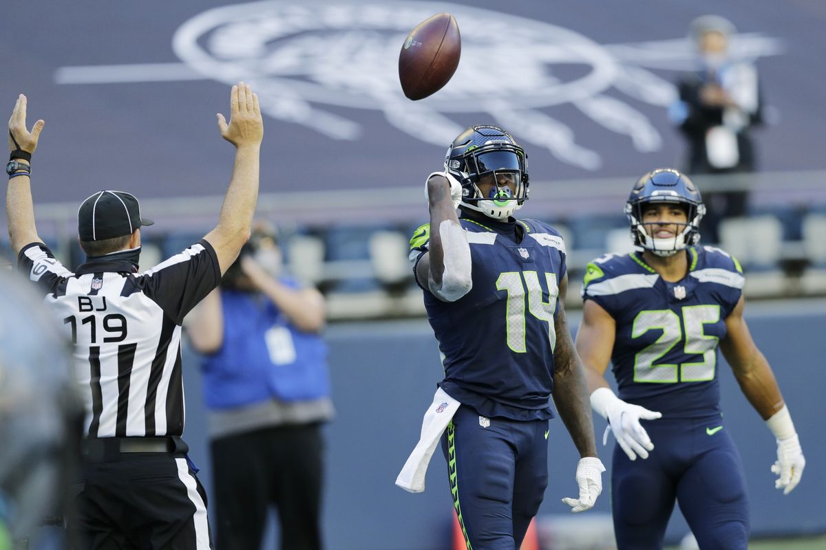 Seattle Seahawks wide receiver DK Metcalf (14) tosses the ball as he stands with running back Travis Homer (25) after Metcalf scored a touchdown against the Dallas Cowboys during the second half Sunday in Seattle.  (John Froschauer)