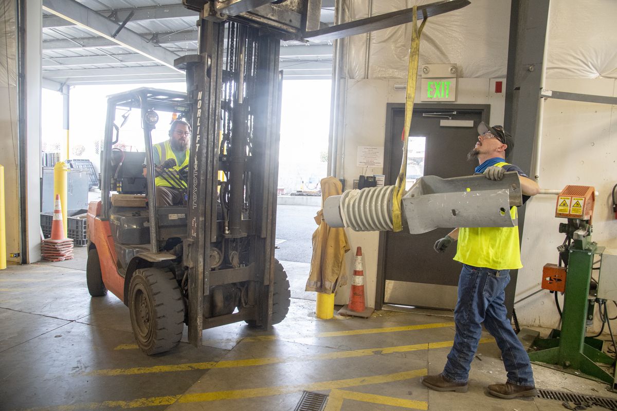 Malachi Chaney drives a forklift while his co-worker Scott Strickland guides a heavy insulator bound for recycling Sept. 9. Both of them work at the Investment Recovery Center at Avista Utilities where they sort cast-off wiring and equipment for recycling, an effort which employs nine people with intellectual and developmental disabilities. The ARC of Spokane provides the workers, and the partnership is 30 years old.  (Jesse Tinsley/The Spokesman-Review)