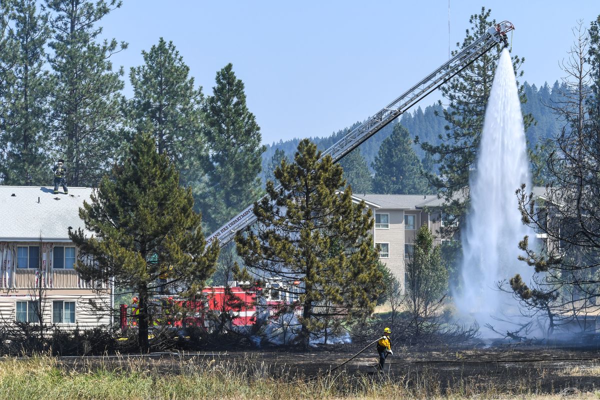 Spokane Fire Department Aerial Truck 11 hits hot spots on a fire Friday near the old Shopko store on South Regal Street in Spokane. (DAN PELLE/THE SPOKESMAN-REVIEW)