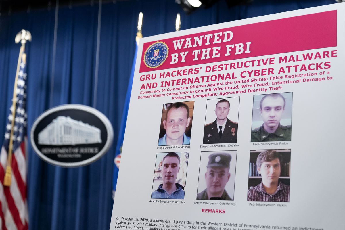 A poster showing six wanted Russian military intelligence officers is displayed before a news conference at the Department of Justice, Monday, Oct. 19, 2020, in Washington.  (Andrew Harnik)