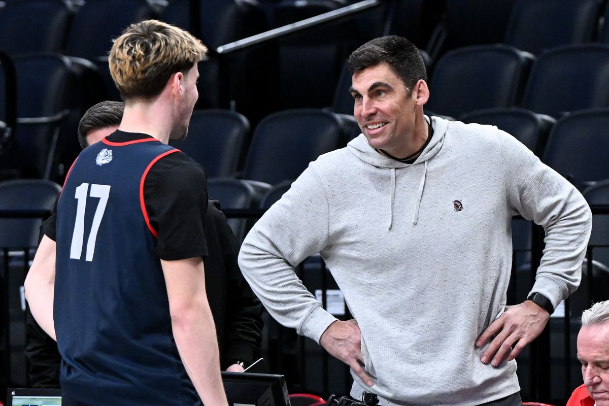 Wally Sczerbiak smiles as he chats with Gonzaga Bulldogs guard Mario Saint-Supery (17) during a practice on Wednesday, Mar 18, 2026, before their NCAA basketball tournament first round matchup agains the Kennesaw State Owls tomorrow at Moda Center in Portland, Ore.  (Tyler Tjomsland / The Spokesman-Review)