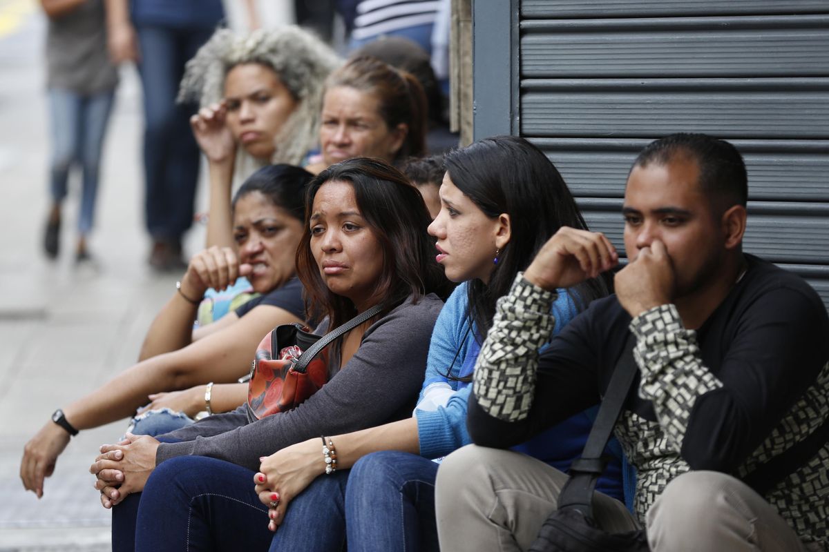 People wait outside police headquarters as their relatives, who were at the stampede at a crowded nightclub, are declaring to the authorities in Caracas, Venezuela, Saturday, June 16, 2018. (Ariana Cubillos / Associated Press)