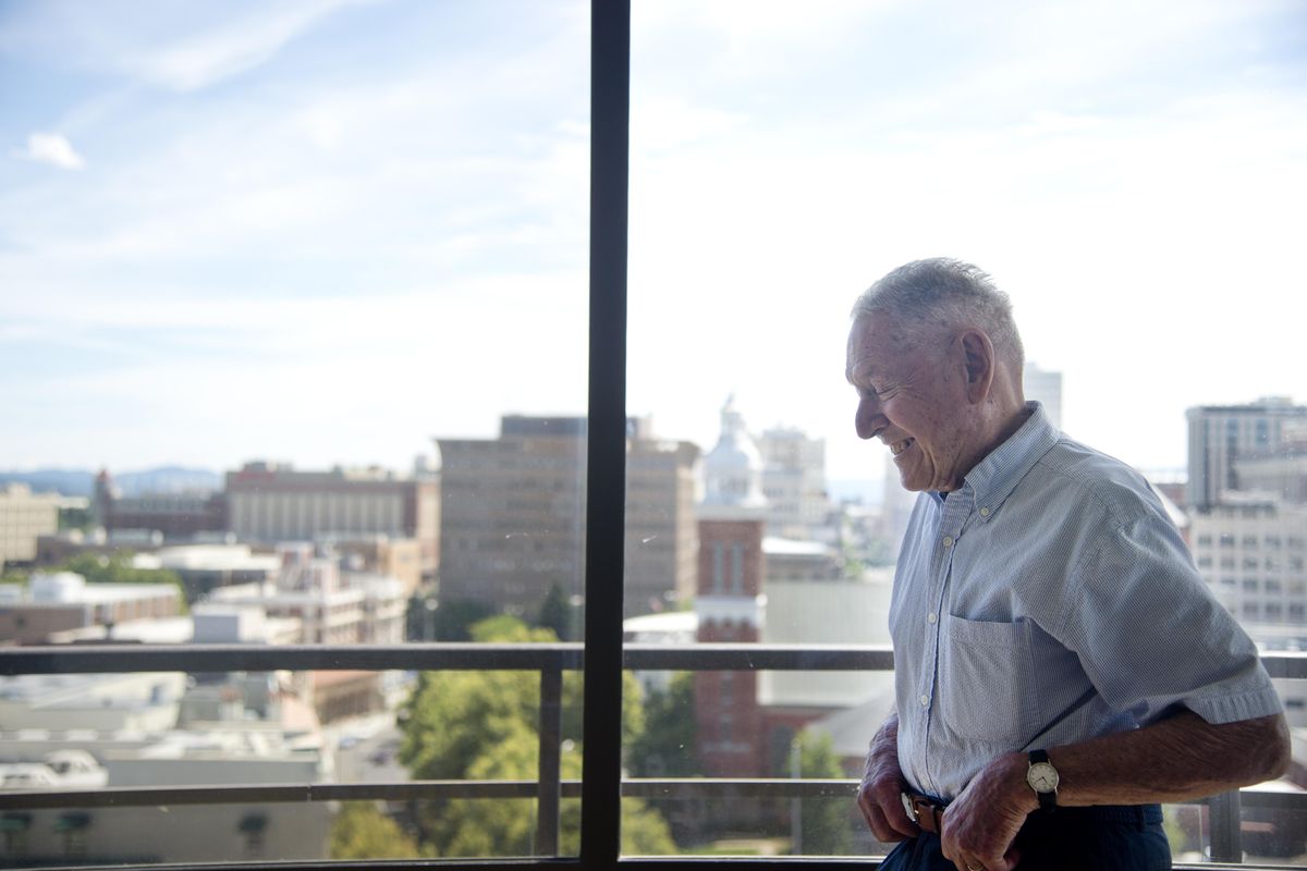 Standing before the skyline of Spokane, Architect Warren Heylman, now 92, laughs as he talks about his philosophy of design from the apartment he shares with his wife in the Riverside Falls apartment tower, which he also designed. Heylman left his modernist stamp on Spokane as he designed several important Spokane buildings, a handful of houses and some businesses in his career, which spanned from World War II to the present. (Jesse Tinsley / The Spokesman-Review)
