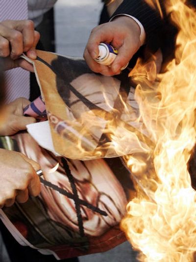 
South Korean protesters burn  pictures of North Korean leader Kim Jong Il during a rally  in downtown Seoul on Wednesday. 
 (Associated Press / The Spokesman-Review)