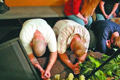Celebrate Recovery participants kneel in prayer during an altar call at a March 23 meeting.
