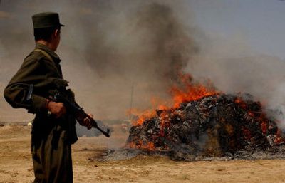 
An Afghan policeman stands guard as a pile of seized drugs is destroyed on the outskirts of Kabul, Afghanistan, last year. 
 (File/Associated Press / The Spokesman-Review)