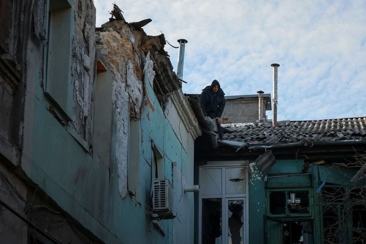 A resident on a roof inspects a damaged apartment building at the site of a Russian missile and drone strike, amid Russia’s attack on Ukraine, in Odesa, Ukraine Saturday. (Nina Liashonok/Reuters)