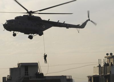 A National Security Guard commando comes down a rope to reach the top of Nariman House, a Jewish center under siege Friday by suspected militants in Mumbai, India.   (Associated Press / The Spokesman-Review)