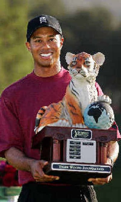 
Tiger Woods holds up his trophy after winning the Target World Challenge on Sunday.
 (Associated Press / The Spokesman-Review)