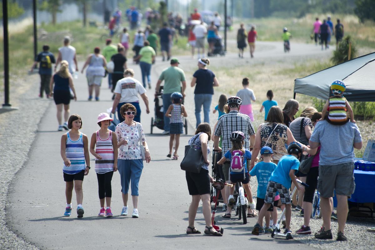 FILE – Crowds of people participate in a one-mile fun walk after the ribbon-cutting ceremony for the new Appleway Trail, July 9, 2015, in Spokane Valley. (Dan Pelle / The Spokesman-Review)