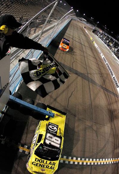 Kyle Busch takes the checkered flag to win the Lucas Oil 150 at Phoenix International Raceway, his second NASCAR Camping World Truck Series victory at the track. (Photo credit: Tom Pennington/Getty Images) (Tom Pennington / Getty Images North America)