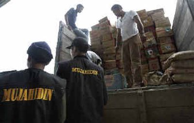 
Volunteers from Laskar Mujahidin, a radical Islamic group with alleged links to al Qaeda, unload relief goods at Banda Aceh's airport, in the tsunami-stricken Aceh province on Sumatra, Indonesia, on Thursday. 
 (Associated Press / The Spokesman-Review)