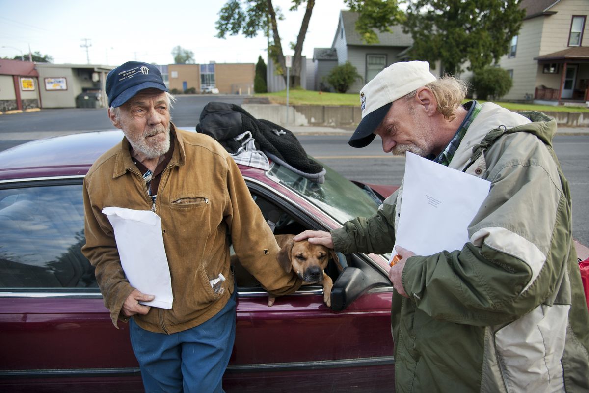 Dick Stallman, left, and Ryan Doody comfort Stallman’s dog, Deuce, after a fire broke out in Stallman’s home early Wednesday on East Empire Avenue in Spokane. Jay Richardson, a housemate of the men, was rushed to a hospital in critical condition and later died. (Dan Pelle)