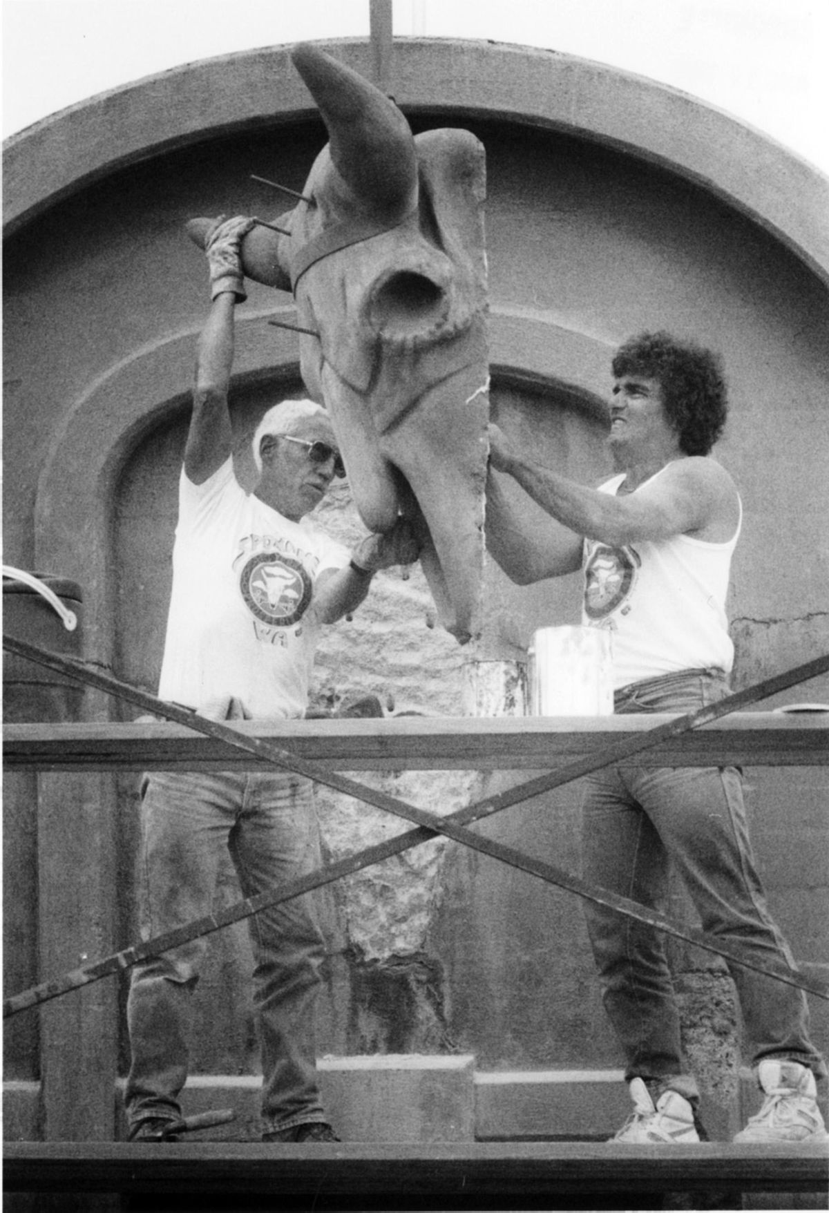 City employee Jack Fruit and sculptor Don Rodgers prepare to put a buffalo skull, created by Rodgers, in place on an archway on the Monroe Street Bridge in 1989. (Shawn Jacobson / The Spokesman-Review)