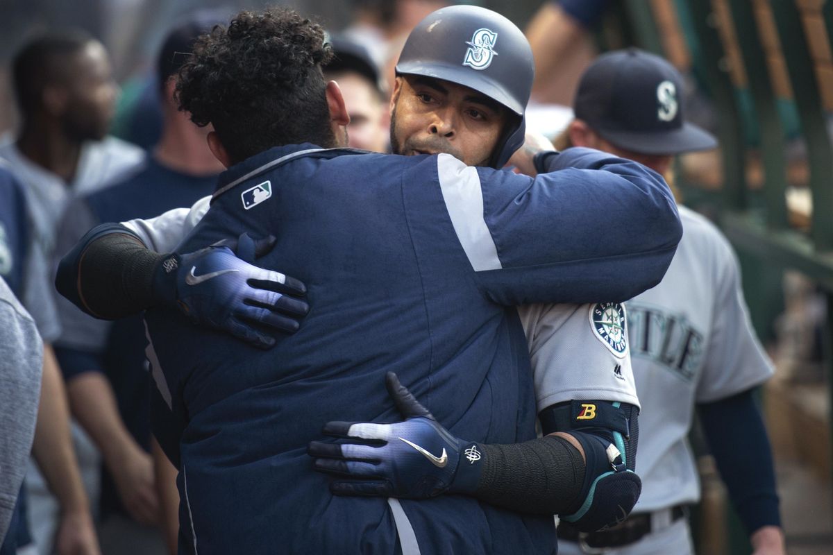Seattle’s Nelson Cruz, back, celebrates his solo home run with Felix Hernandez during the second inning against the Los Angeles Angels in Anaheim, Calif., on Saturday. (Kyusung Gong / AP)