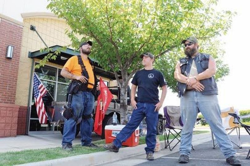 Mike Dill, Matt Dillard and Josh Burns keep watch Tuesday outside the Armed Forces Career Center at Nez Perce Plaza in Lewiston. The members of the Three Percenters Club Idaho are part of a statewide effort to protect the military men and women recruiters in response to a shooting last week in Tennessee. (Kyle Mills / Lewiston Tribune)